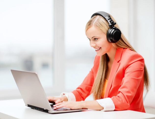 Woman wearing headset and typing on a laptop