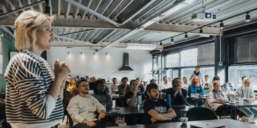 Young woman making a presentation to a room full of people