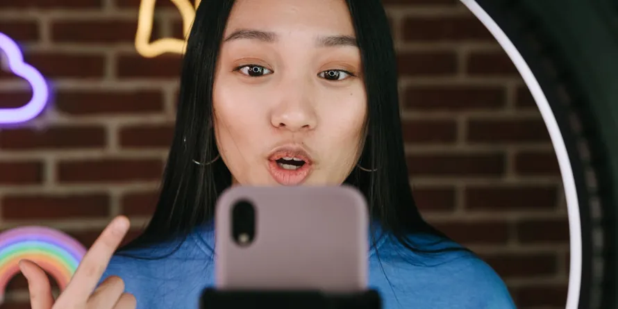 Youg east asian woman talking in front of a mobile phone