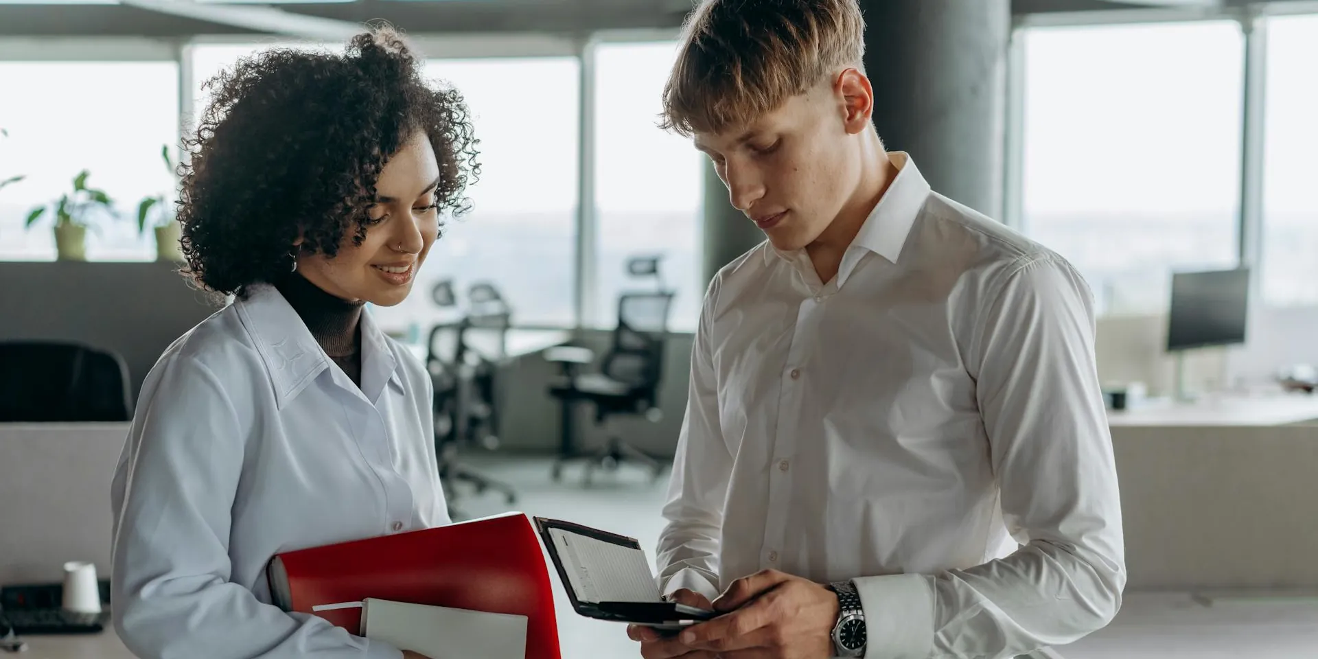 A woman and a man standing and looking at a document