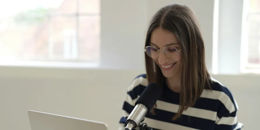 Woman wearing glasses speaking to a microphone