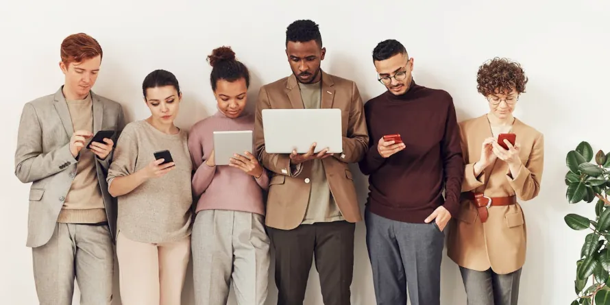 A line of six people looking at their mobile devices